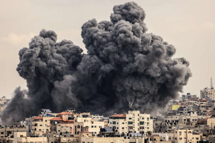 A plume of smoke rises in the sky of Gaza City during an Israeli airstrike on October 9, 2023. Israel relentlessly pounded the Gaza Strip overnight and into October 9 as fighting with Hamas continued around the Gaza Strip, as the death toll from the war against the Palestinian militants surged above 1,100. (Photo by MAHMUD HAMS / AFP)