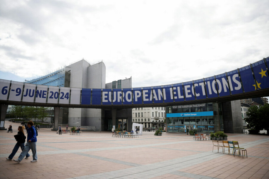 FILE PHOTO: People walk near a sign for the upcoming European elections, at the EU Parliament in Brussels, Belgium May 23, 2024. REUTERS/Johanna Geron/File Photo